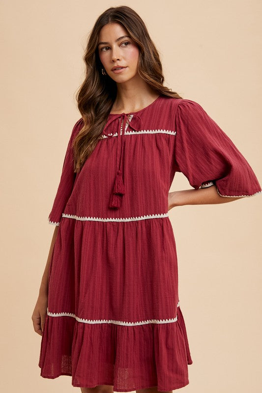 Aaliyah® | Tiered dress with tassels and contrast trim, tied neckline, half sleeves
